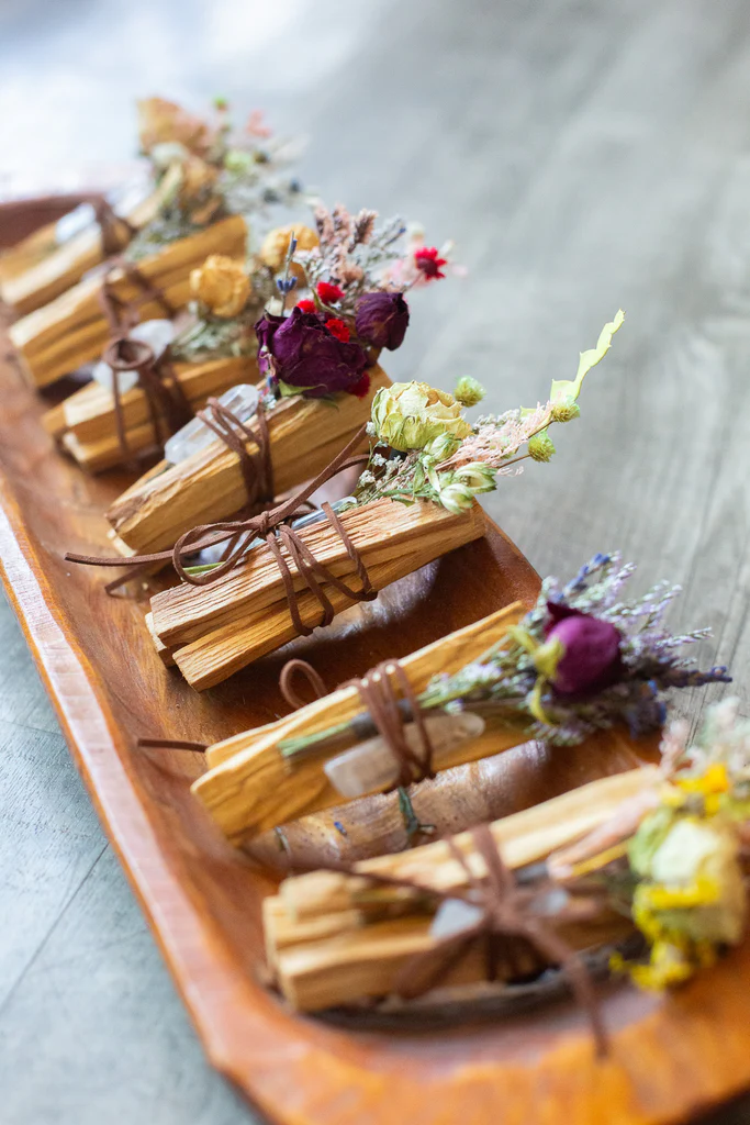 Bündel von Palo Santo mit jeweils bunten, unterschiedlichen Kräutern verziert.