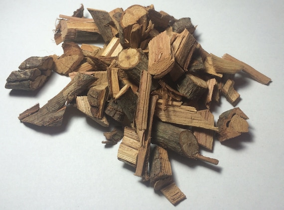 Getrocknete Rinden- und Holzstücke der Heilpflanze Clavo Huasca liegen als kleiner Haufen auf einem weißen Hintergrund. Die unterschiedlich großen, länglichen Stücke zeigen eine braune Rinde und helleres, frisch gespaltenes Holz im Inneren. Das Material wird traditionell für die Zubereitung von Tee oder pflanzlichen Auszügen verwendet.