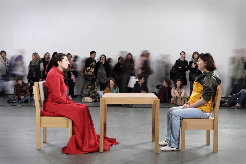     Marina Abramović bei ihrer Performance The Artist Is Present, bei der sie im MoMA in New York einem Museumsbesucher an einem Tisch gegenübersitzt.