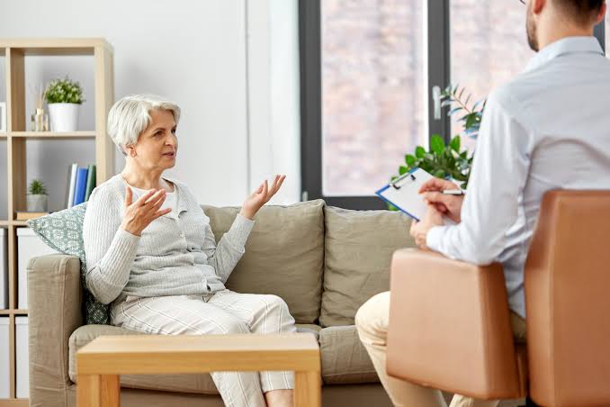 Patientin im Gespräch mit einem Psychotherapeuten während einer Psychotherapiesitzung