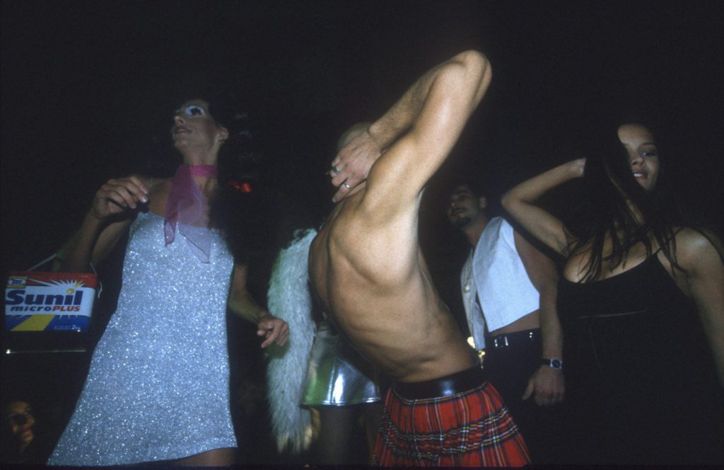 Ausgelassene Clubbesucher tanzen in auffälligen Outfits auf einer Techno-Party – Momentaufnahme aus der Technoszene.